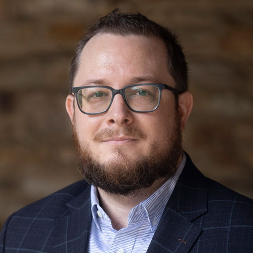 Bill Harder profile picture. White man with a beard and glasses wearing a suit.