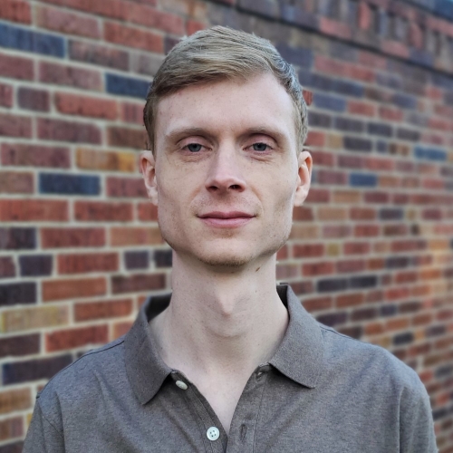 Profile picture of Michael McCreary. White man with short blond hair against a brick background.