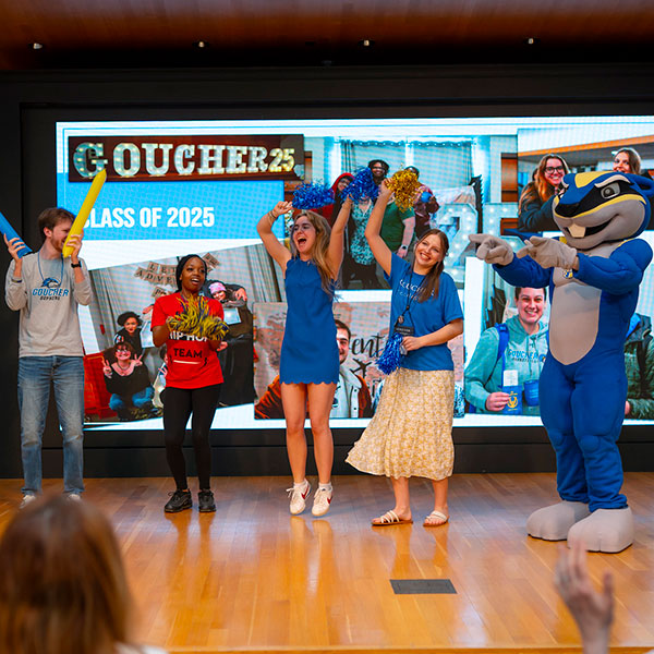 Class of '25 cheer on stage weaing blue and gold during Alumni Weekend '25.