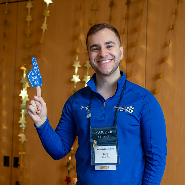 Joey Fink '15 smiles while wearing a Goucher blue shirt.
